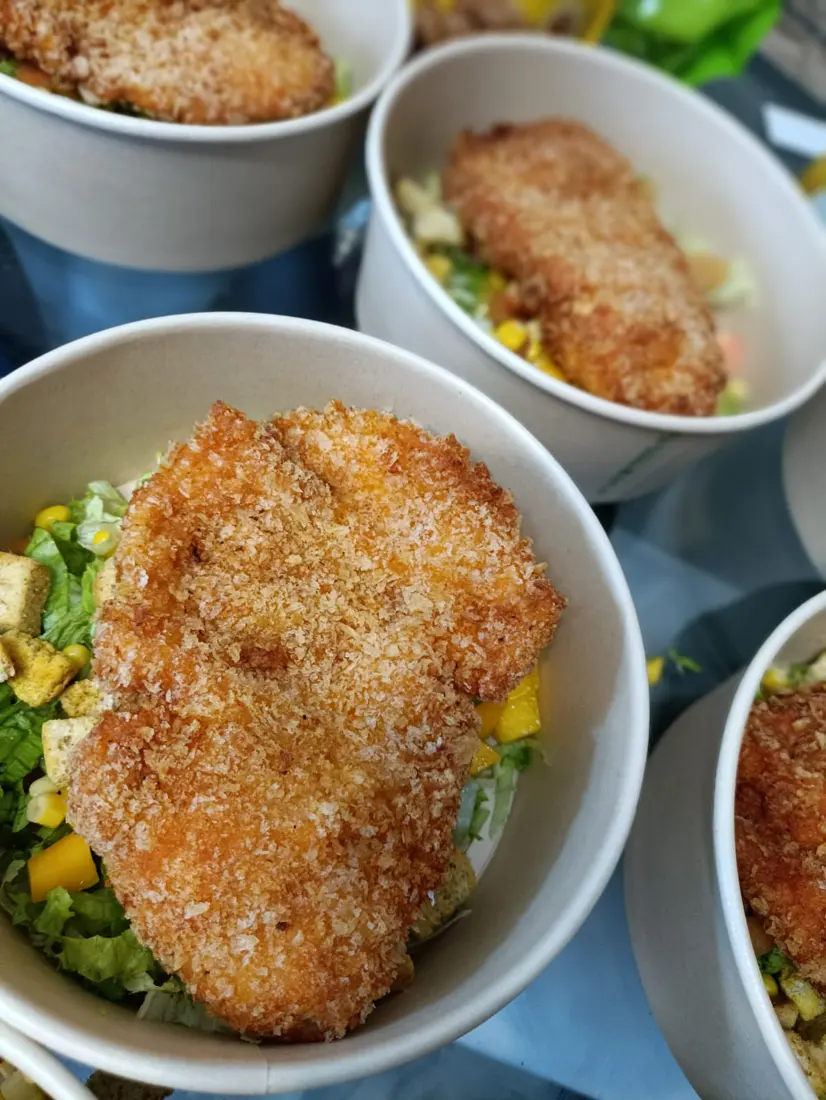 Bowl de pechuga apanada con ensalada, mango y crotones